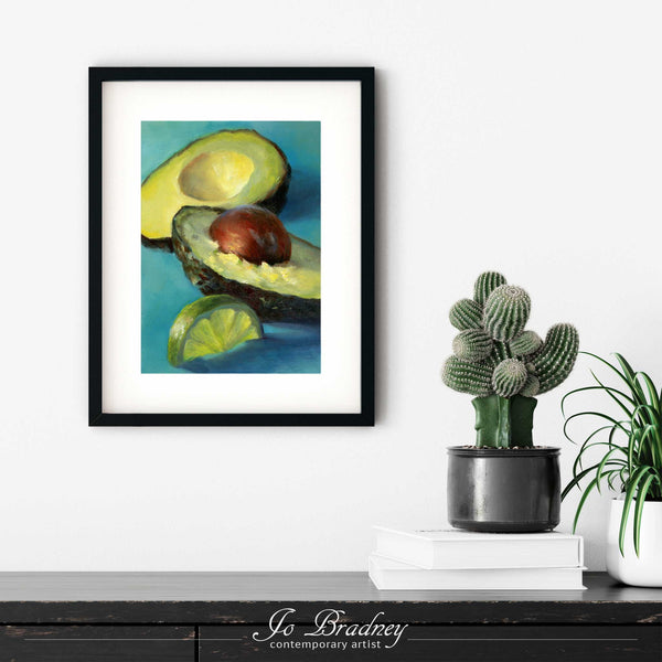 A turquoise avocado and lime painting art print in a simple, elegant black picture frame on a living room or dining room wall, with a pile of books and a cactus. The print size ranges from 4x6 to 11x14 inches