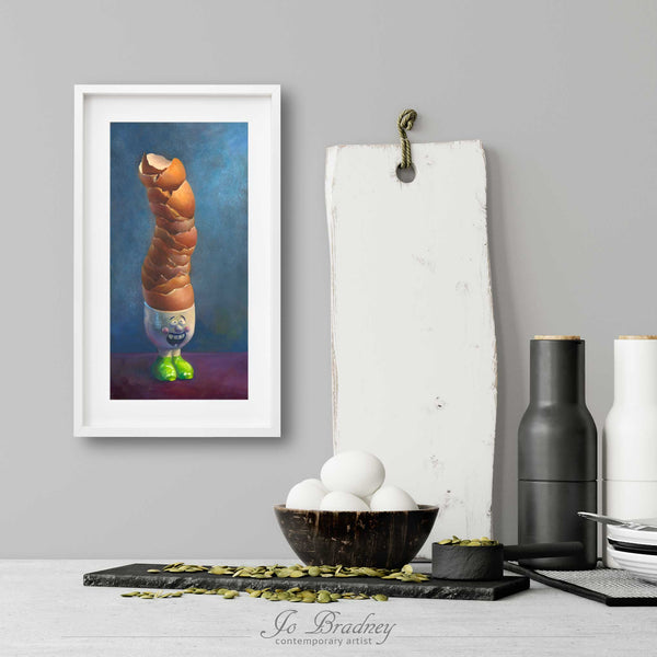 A funny egg art print in a simple, elegant white picture frame on a kitchen wall. There is a bowl of eggs, and a chopping board for scale. The print is 4 eggs wide. The smallest vertical print is 4x8 inches, the largest is 10x20 inches.