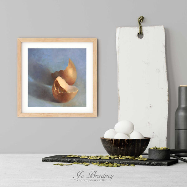 An egg art print in a simple, elegant wood picture frame on a modern farmhouse kitchen wall. There is a bowl of eggs, and a chopping board for scale. The print is 5 eggs tall. The smallest square print is 4 inches, the largest is 12 inches.