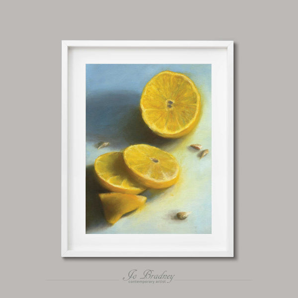 A yellow sliced lemon, sliced on a pale blue background. This archival art print of my fruit still life oil painting is shown in simple white picture frame.