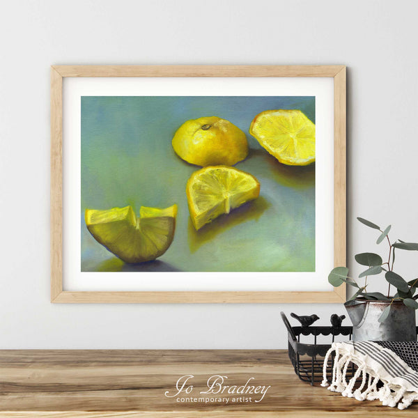 A lemon oil painting art print in a simple, elegant wood picture frame on a dining room or living room wall. There are flowers in a teapot on a metal tray set on a wood table. The smallest horizontal print is 4x6 inches, the largest is 11x14 inches.