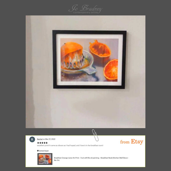 5 star customer review. Photo review from a happy customer showing the orange juice art print in her new breakfast nook. Rachel writes, Excellent print! It came as vibrant as I had hoped, and I love it in the breakfast room!