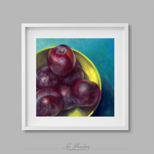 Dark purple plums in a lme green bowlon a peacock blue background. This archival art print of my fruit still life oil painting is shown in simple white square picture frame.