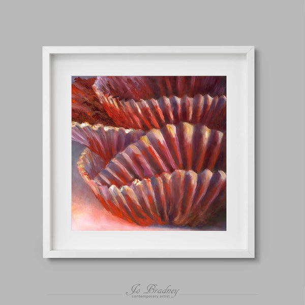 A stack of frilly red velvet cupcake papers red and pink. This archival art print of my snack food still life oil painting is shown in simple white picture frame.
