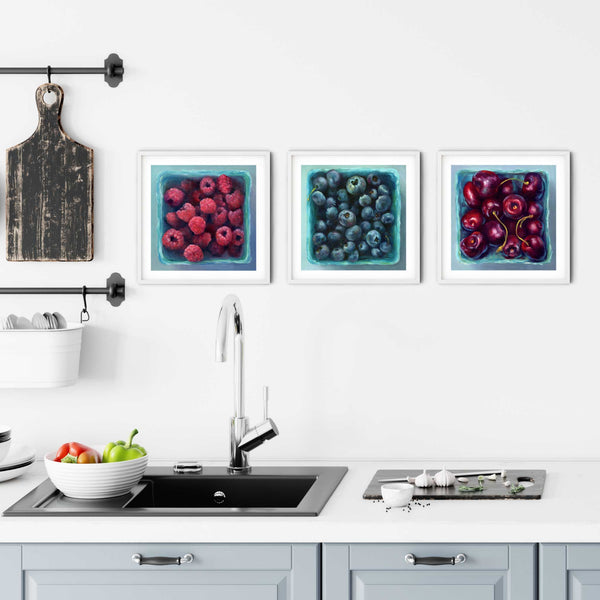 a Kitchen art wall gallery using 3 of my square summer berry art prints. Placed above a modern farmhouse kitchen sink with a rustic chopping board and fresh vegetables.