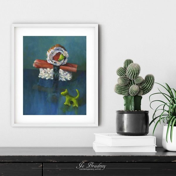 A sushi painting art print in a simple, elegant white picture frame on a living room or dining room wall, with a pile of books and a cactus. The print size ranges from 4x6 to 11x14 inches.