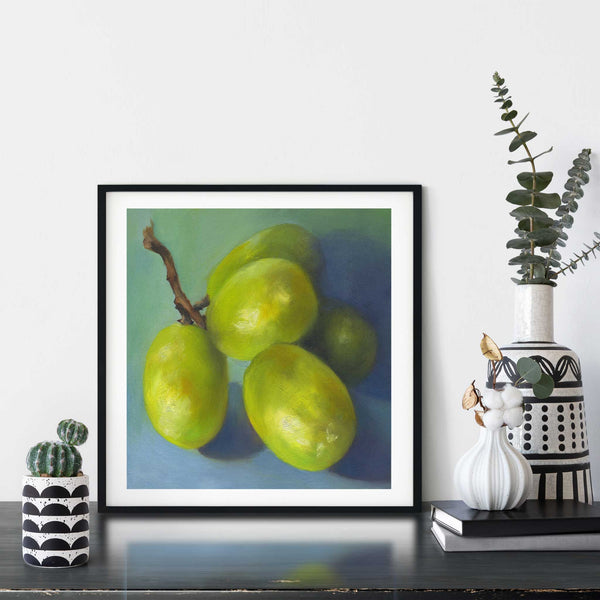 A grapes still life oil painting art print framed in a simple, elegant black picture frame on a dining room or living room wall. There are flowers in vase, set on a wood buffet table. The smallest square print on paper is 4 inches, the largest is 12 inches.