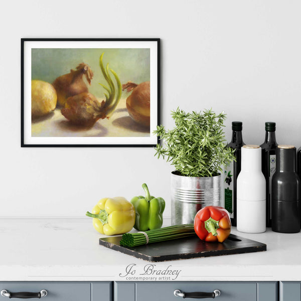 A sprouting onion painting art print in a simple, elegant black picture frame on a kitchen wall. There is a chopping board, vegetables, herbs and some bottles. The art print is as large as three bell peppers. The largest size is 11 inches high by 14 wide